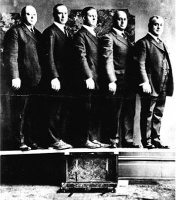 シュウェイダー社のたった一個のトランクに支えられた板の上に、体重の合計が500キロに近い創業者のジェシー・シュウェイダーと三人の兄弟と父親が立っている写真
